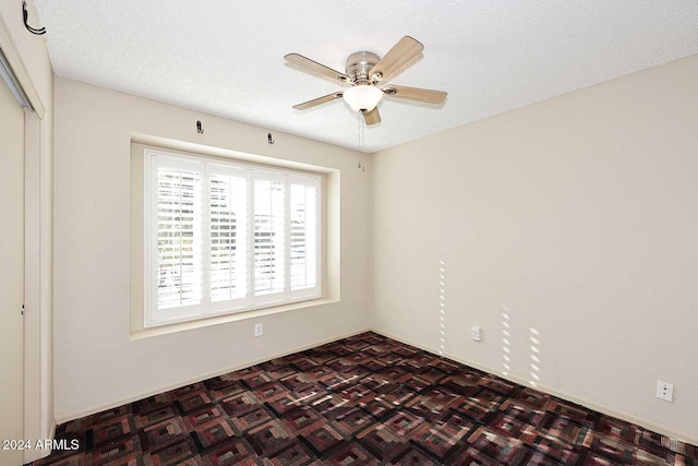 spare room with parquet flooring, a textured ceiling, and ceiling fan