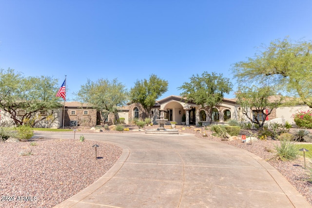 mediterranean / spanish-style home featuring curved driveway