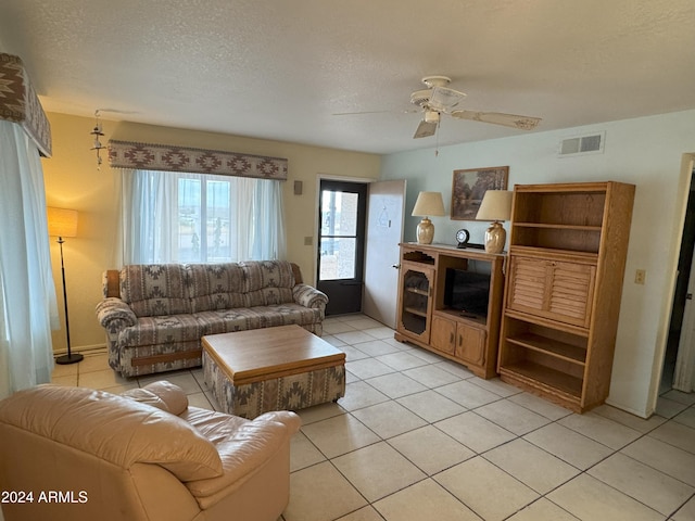 tiled living room featuring ceiling fan and a textured ceiling