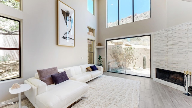 25555 N Windy Walk Dr Unit 64, Scottsdale, AZ 85255 - living area featuring plenty of natural light, a towering ceiling, a stone fireplace, and wood finished floors