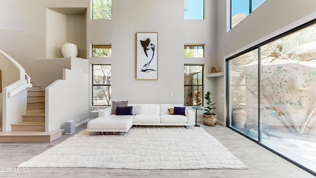 25555 N Windy Walk Dr Unit 64, Scottsdale, AZ 85255 - living room featuring a towering ceiling, wood finished floors, and stairway