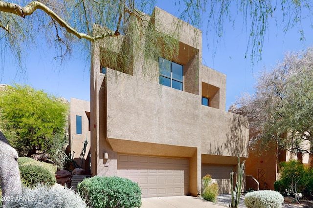 25555 N Windy Walk Dr Unit 64, Scottsdale, AZ 85255 - pueblo-style home with an attached garage, stucco siding, and concrete driveway