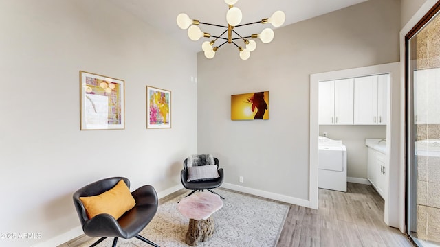 25555 N Windy Walk Dr Unit 64, Scottsdale, AZ 85255 - sitting room with light wood-type flooring, a chandelier, washing machine and clothes dryer, and baseboards