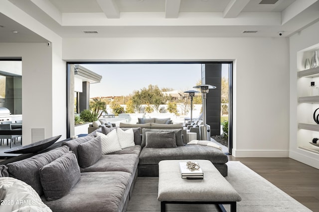 living room featuring dark wood-type flooring, beam ceiling, and built in features