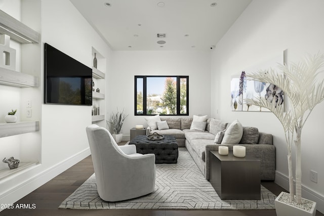 living room with dark hardwood / wood-style flooring and built in shelves