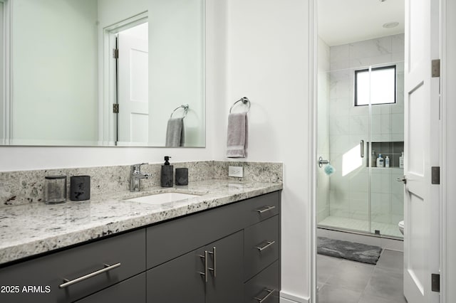 bathroom featuring vanity, a shower with shower door, tile patterned floors, and toilet