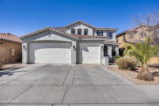 mediterranean / spanish-style house featuring a tile roof, stucco siding, concrete driveway, and a garage