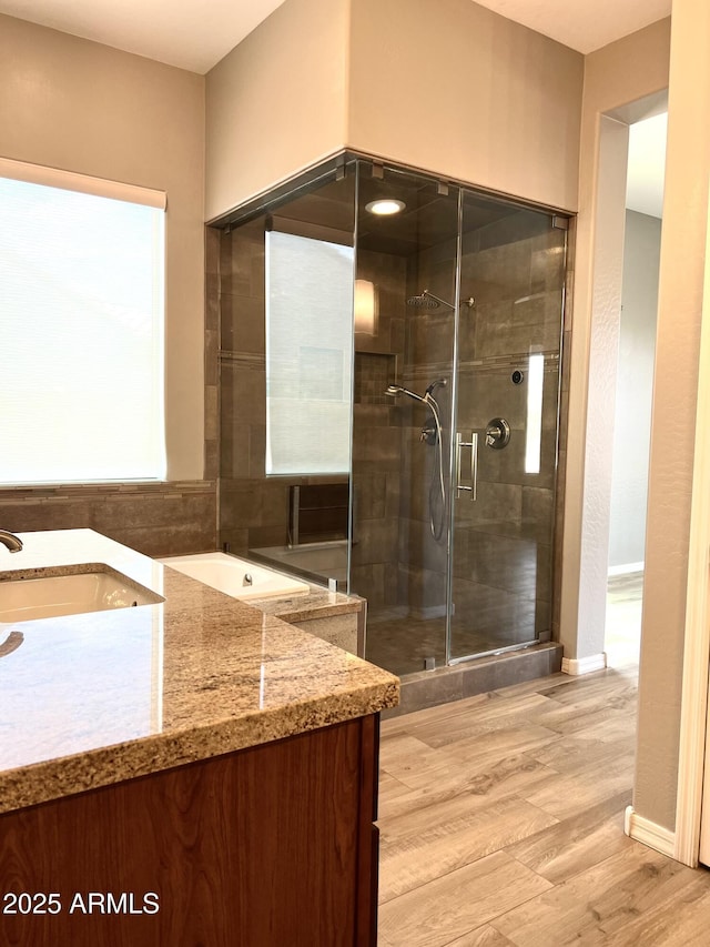 bathroom featuring vanity, hardwood / wood-style flooring, and a shower with door