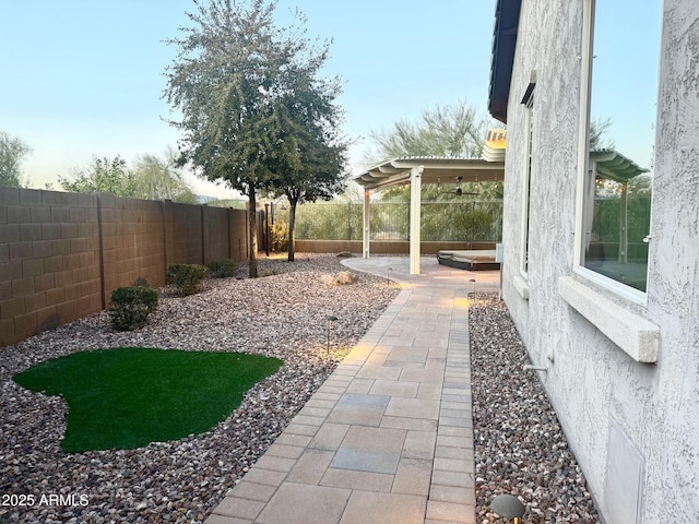 view of yard featuring ceiling fan and a patio area