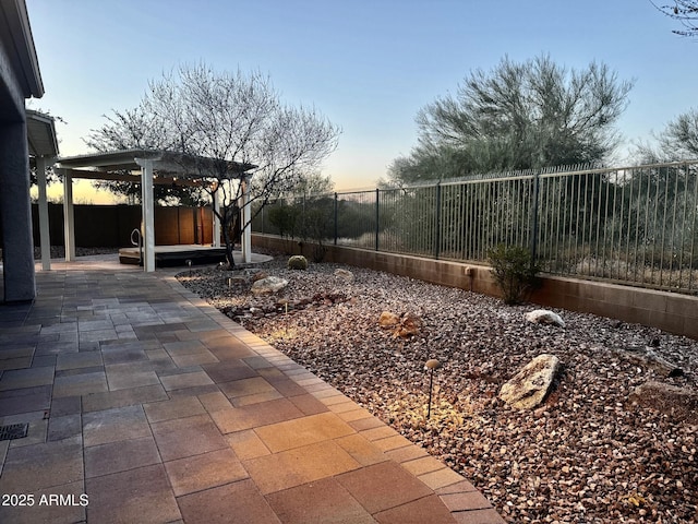 yard at dusk featuring a patio and a pergola