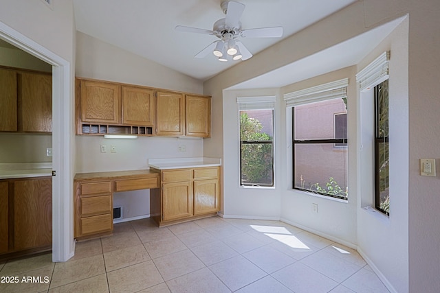 3928 N 151st Ave, Goodyear, AZ 85395 - kitchen featuring light tile patterned floors, light countertops, built in desk, and lofted ceiling