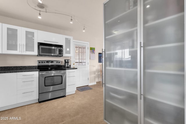 kitchen with white cabinets, modern cabinets, glass insert cabinets, stainless steel appliances, and track lighting