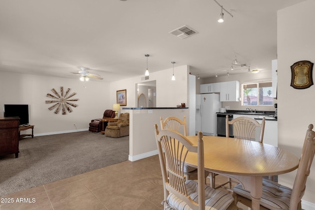 dining area with light tile patterned flooring, light carpet, visible vents, a ceiling fan, and track lighting