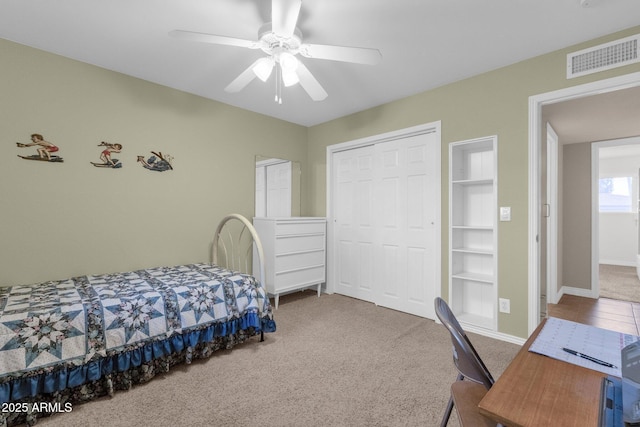 carpeted bedroom featuring baseboards, a closet, visible vents, and a ceiling fan