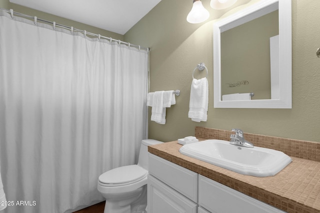 bathroom featuring curtained shower, vanity, and toilet