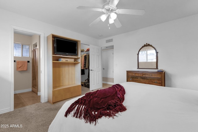 carpeted bedroom with a spacious closet, visible vents, a closet, and multiple windows