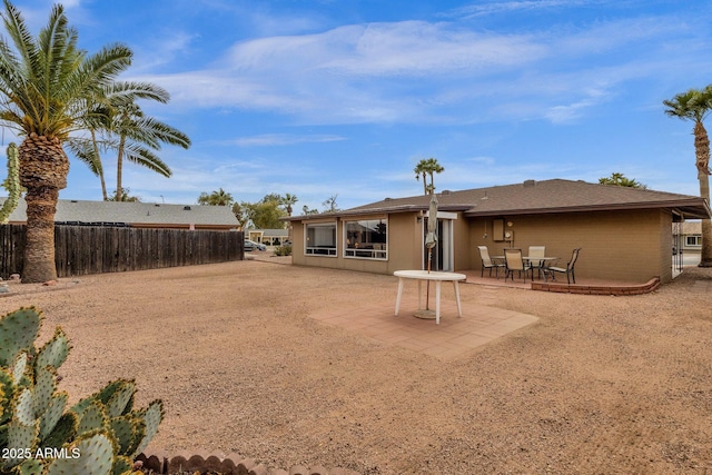 back of property featuring fence and a patio