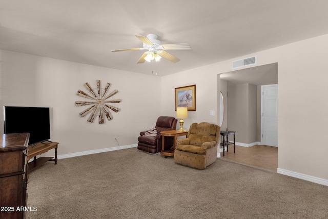 sitting room featuring a ceiling fan, baseboards, visible vents, and carpet flooring