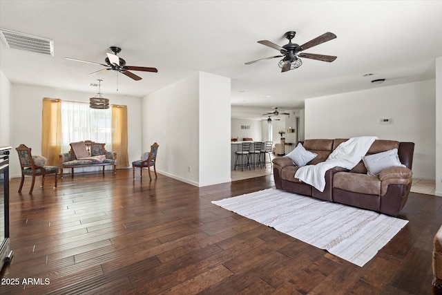 living room featuring dark wood-type flooring and ceiling fan