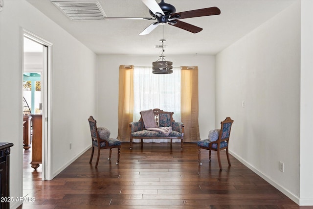 living area featuring dark hardwood / wood-style flooring and ceiling fan