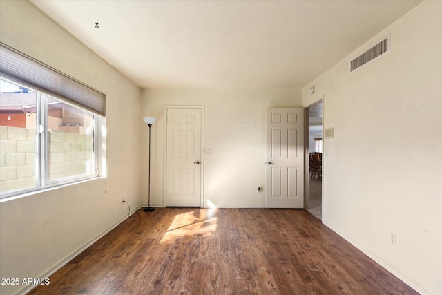 unfurnished room with dark wood-type flooring and plenty of natural light