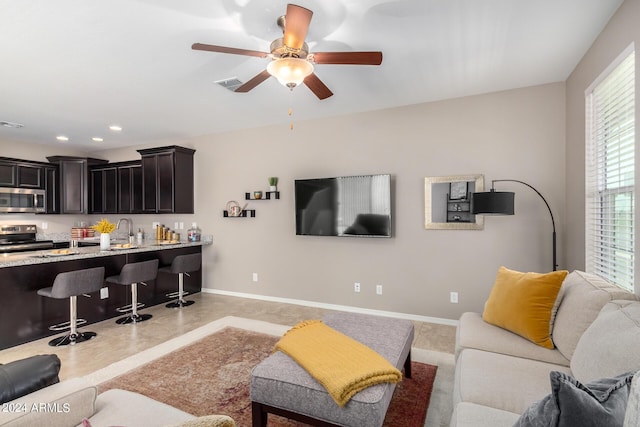 living room featuring ceiling fan and sink