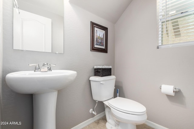 bathroom featuring lofted ceiling and toilet