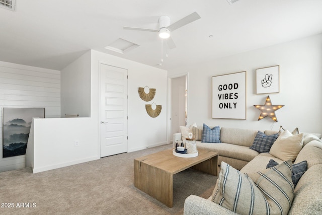 living room featuring attic access, baseboards, visible vents, carpet, and a fireplace