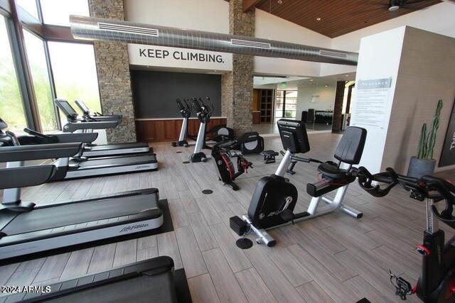 gym with high vaulted ceiling and wood finish floors