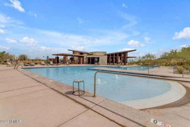 community pool featuring fence and a patio