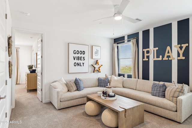 living area featuring carpet, visible vents, and a ceiling fan