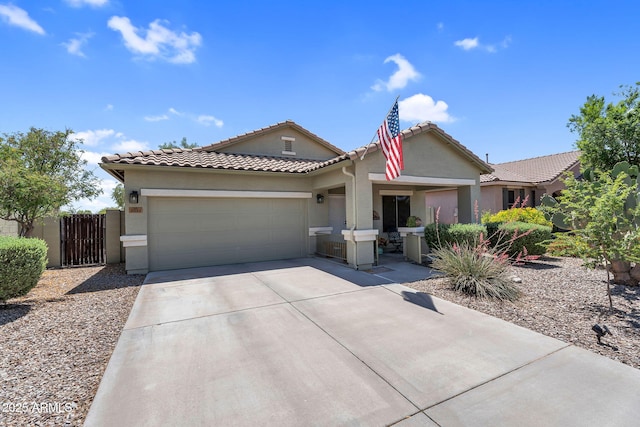 ranch-style home featuring an attached garage, a tile roof, stucco siding, a gate, and driveway