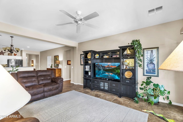 living area featuring baseboards, visible vents, and ceiling fan with notable chandelier