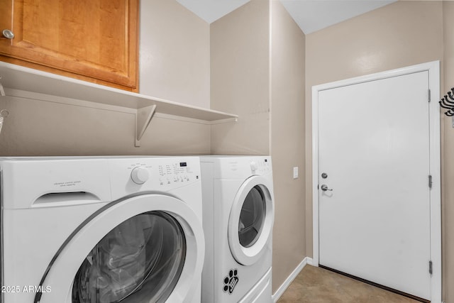 laundry area with baseboards, cabinet space, and washer and dryer