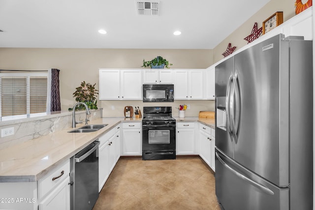 kitchen with visible vents, a sink, white cabinets, and black appliances