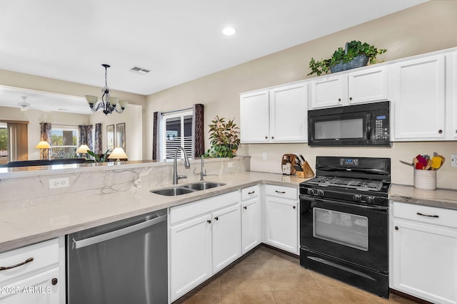 kitchen with a sink, white cabinets, black appliances, and visible vents
