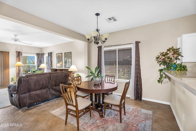 dining space featuring light tile patterned floors, baseboards, ceiling fan with notable chandelier, and visible vents