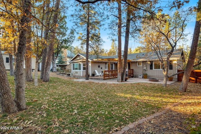 rear view of house featuring a yard, a patio, and an outdoor fire pit