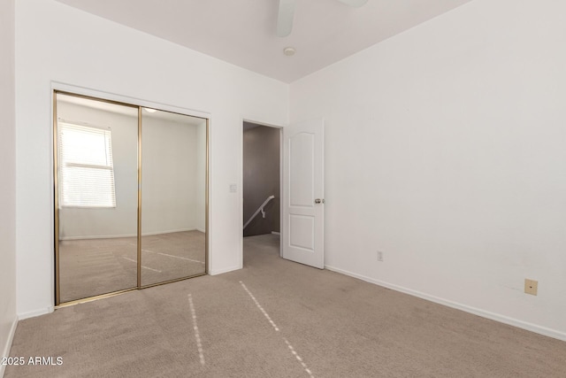 unfurnished bedroom featuring carpet floors, a closet, and ceiling fan