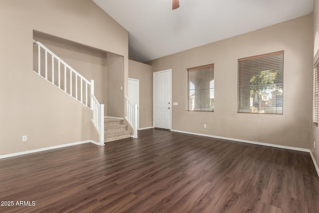 interior space with ceiling fan, vaulted ceiling, and dark hardwood / wood-style flooring