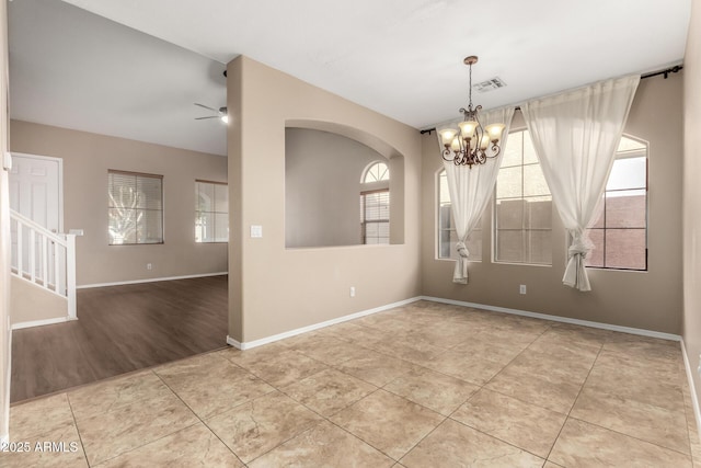 spare room with ceiling fan with notable chandelier and light tile patterned floors