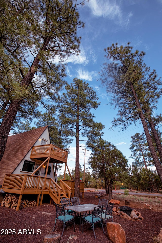 exterior space with a shingled roof, stairway, and a wooden deck