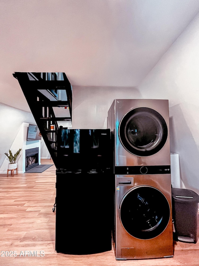 2124 Forest Park Dr, Overgaard, AZ 85933 - laundry area with a fireplace, stacked washer / drying machine, wood finished floors, laundry area, and baseboards