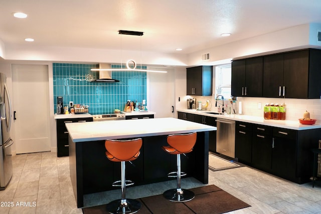 11035 N 37th St, Phoenix, AZ 85028 - kitchen featuring wall chimney range hood, appliances with stainless steel finishes, tasteful backsplash, a sink, and light countertops