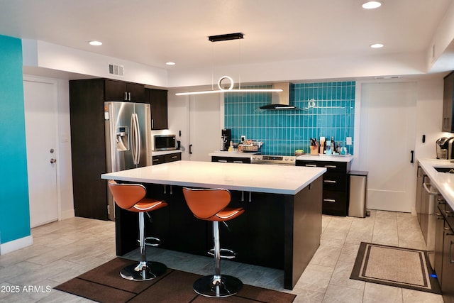 11035 N 37th St, Phoenix, AZ 85028 - kitchen with a kitchen island, visible vents, appliances with stainless steel finishes, light countertops, and wall chimney exhaust hood