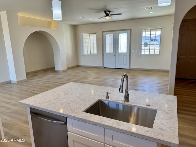 kitchen featuring arched walkways, open floor plan, and a sink