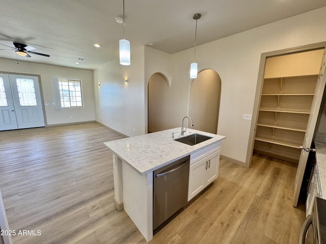 kitchen featuring dishwasher, light wood-style floors, white cabinets, and a sink