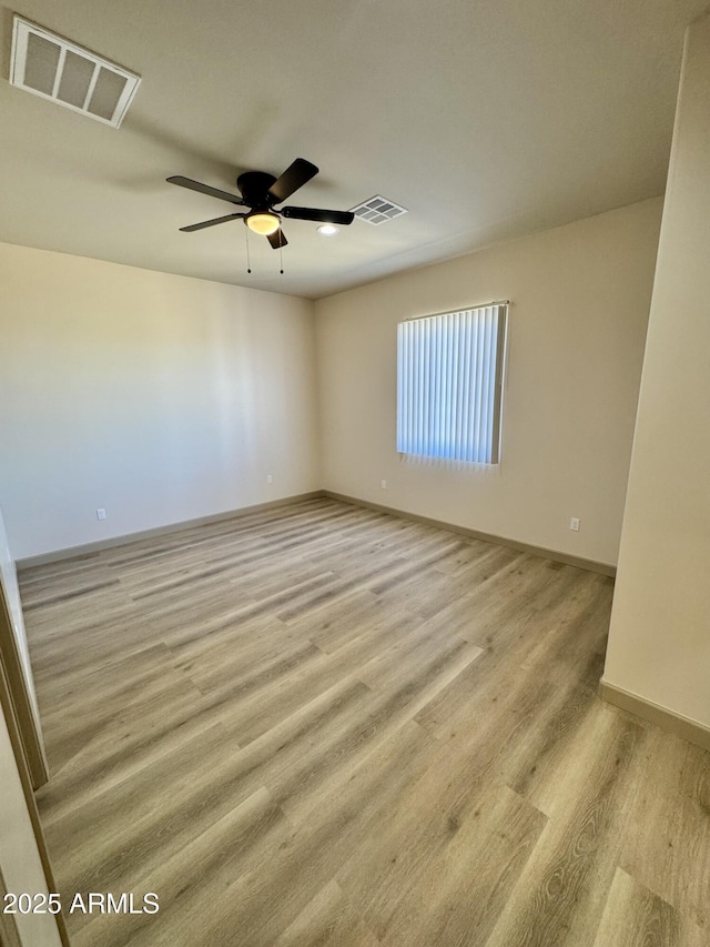 unfurnished room featuring ceiling fan, light wood-type flooring, visible vents, and baseboards