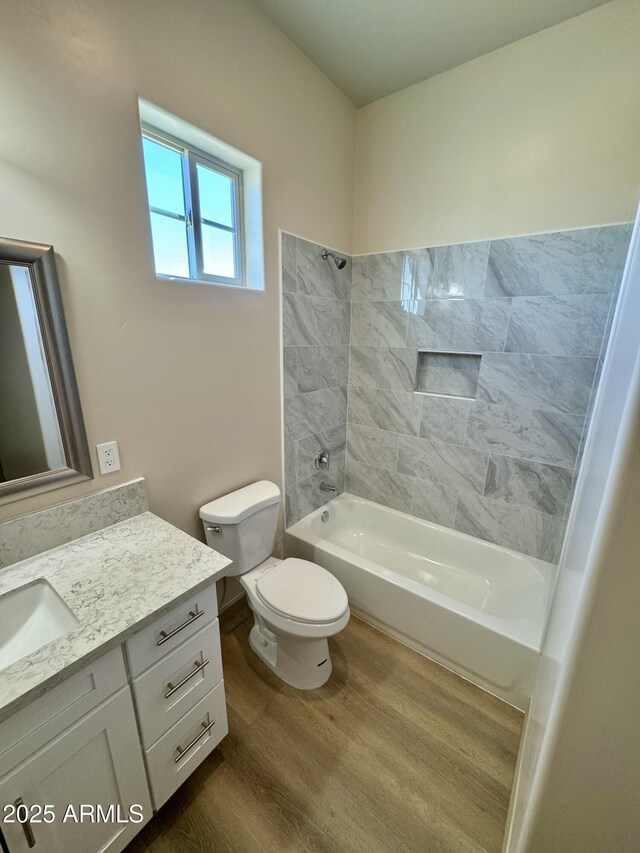 full bathroom featuring toilet, shower / bathing tub combination, wood finished floors, and vanity