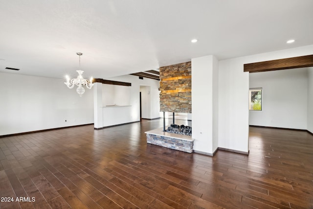 unfurnished living room featuring a fireplace, an inviting chandelier, and dark hardwood / wood-style floors